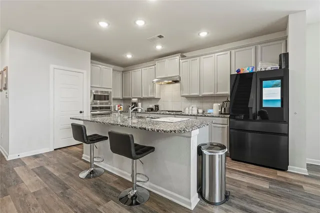 a kitchen with cabinets and chairs