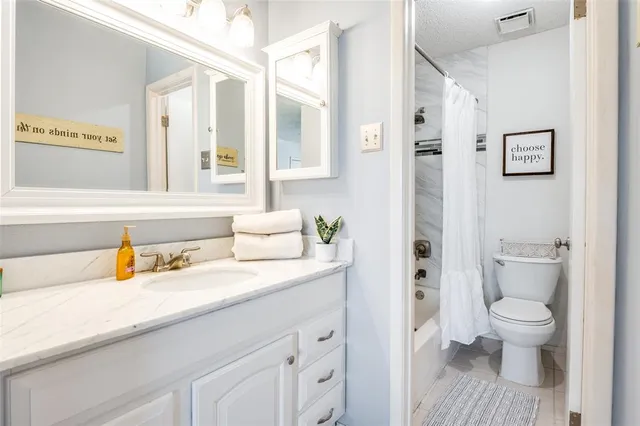 a spacious bathroom with a granite countertop sink toilet and shower