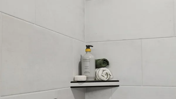 a view of a garden with lawn chairs and a barbeque