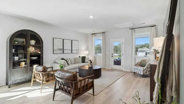 a kitchen with stainless steel appliances granite countertop a stove a refrigerator a sink with white cabinets and wooden floor