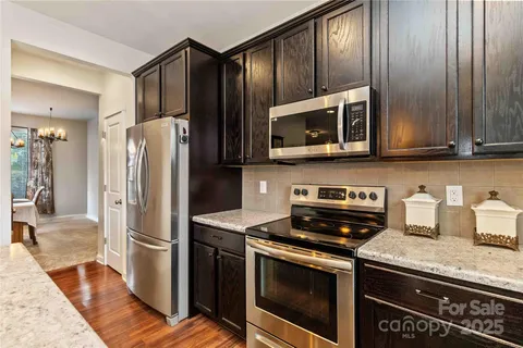 a kitchen with granite countertop a refrigerator stove and microwave