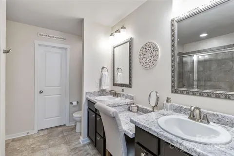 a bathroom with a granite countertop sink a mirror and a shower