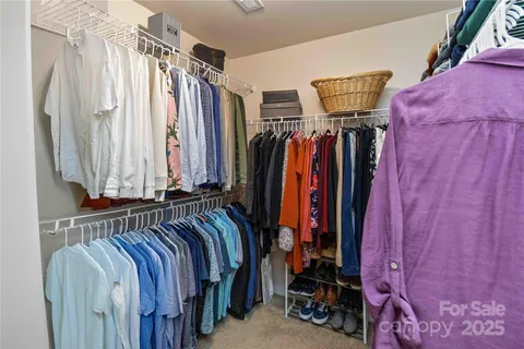 a view of walk in closet with clothes