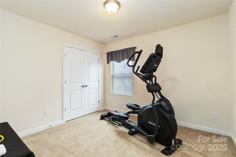a room with gym equipment and view of living room