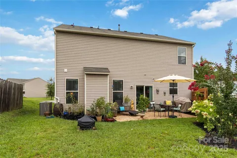 a view of a house with backyard and furniture