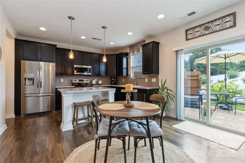 a kitchen with a table chairs refrigerator and a sink