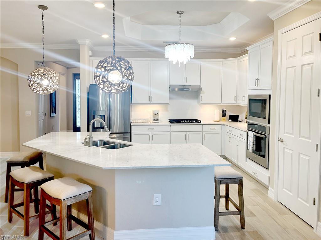 1975 Mustique Street Naples, FL 34120 - Photo 13 of 42 a large kitchen with cabinets and stainless steel appliances