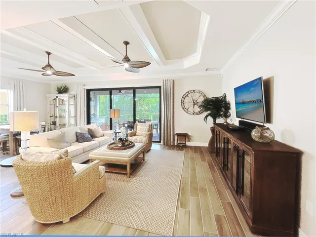 a living room with furniture a flat screen tv and a floor to ceiling window