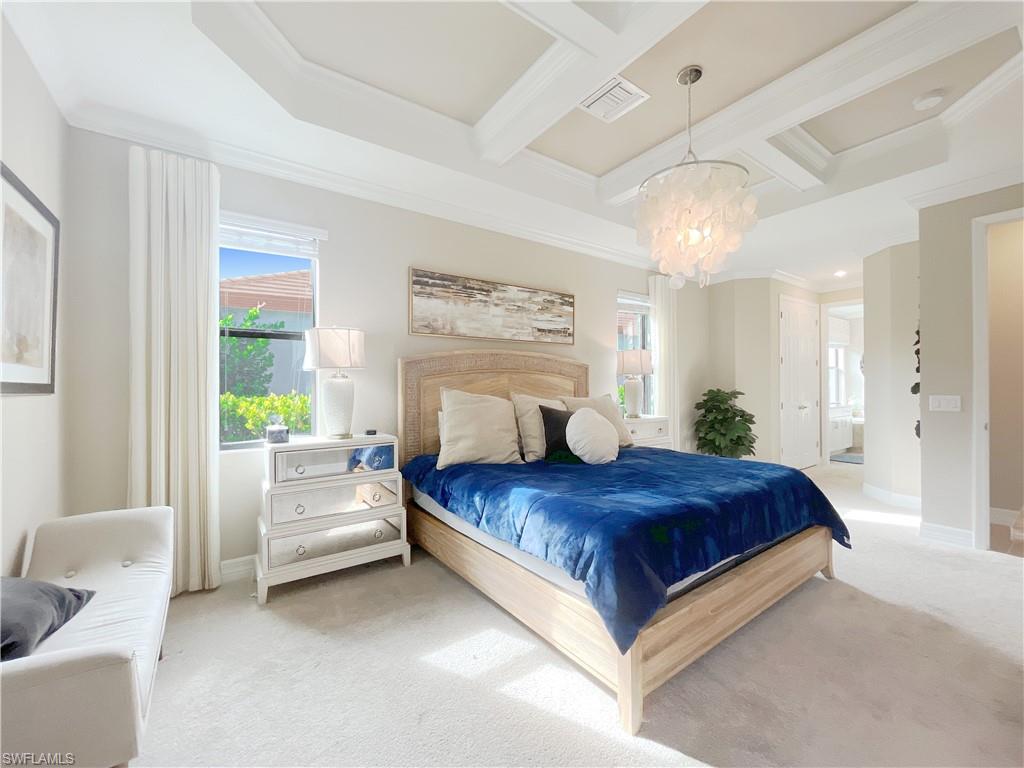 1975 Mustique Street Naples, FL 34120 - Photo 21 of 42 a spacious bedroom with a large bed and a chandelier