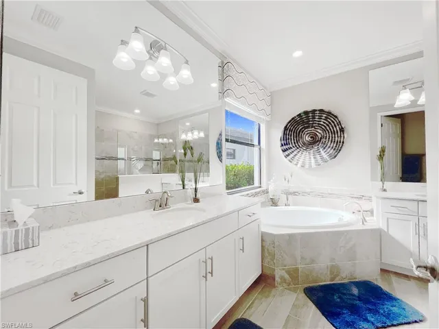 a bathroom with a double vanity sink mirror and bathtub