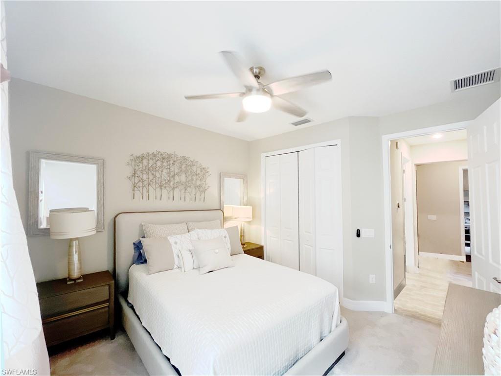 1975 Mustique Street Naples, FL 34120 - Photo 31 of 42 a bedroom with a bed and a lamp