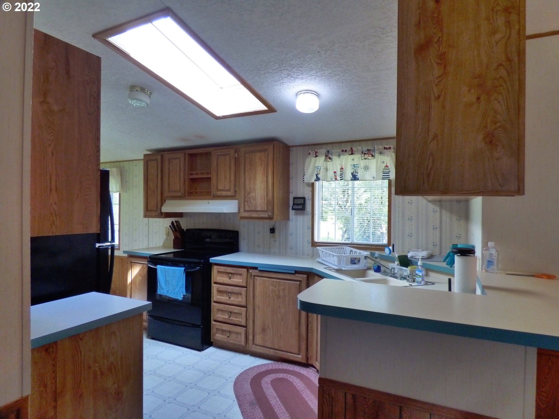 59254 Seven Devils Road Bandon, OR 97411 - Photo 20 of 31 a kitchen with granite countertop a sink stainless steel appliances and cabinets