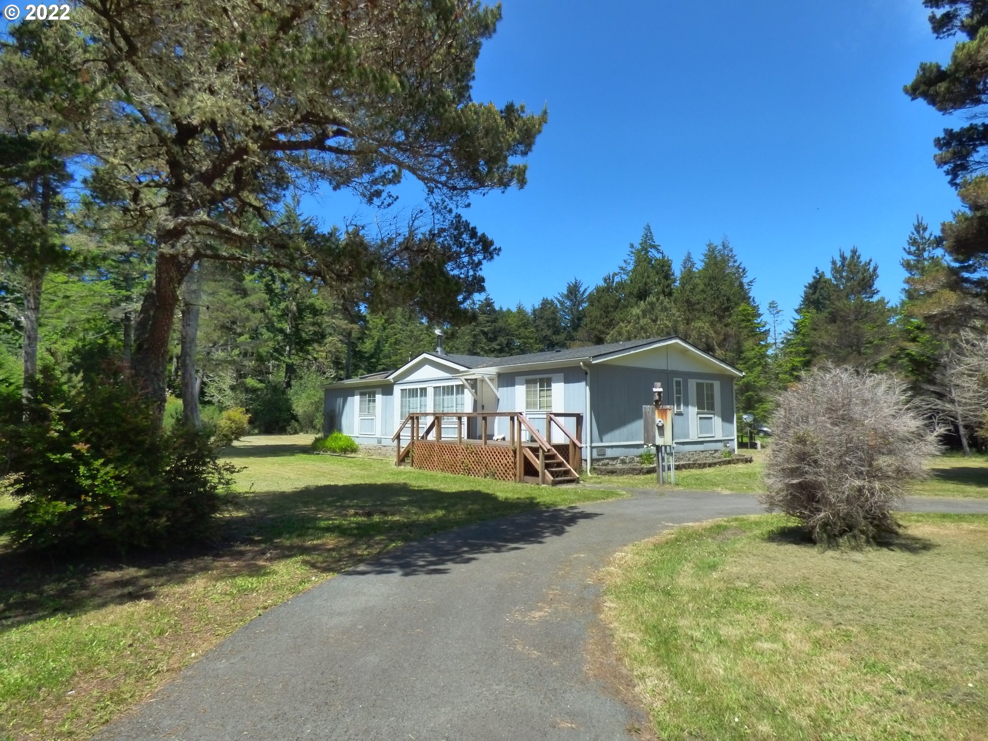 59254 Seven Devils Road Bandon, OR 97411 - Photo 2 of 31 a front view of a house with a garden