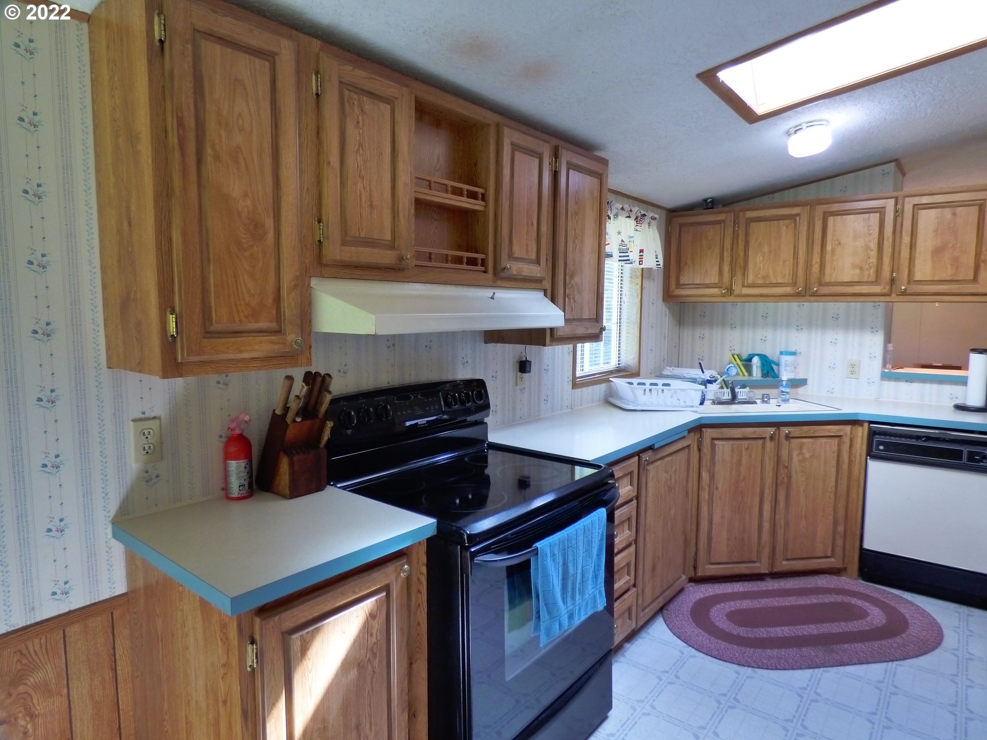 59254 Seven Devils Road Bandon, OR 97411 - Photo 21 of 31 a kitchen with stainless steel appliances granite countertop a stove a sink dishwasher and cabinets with wooden floor