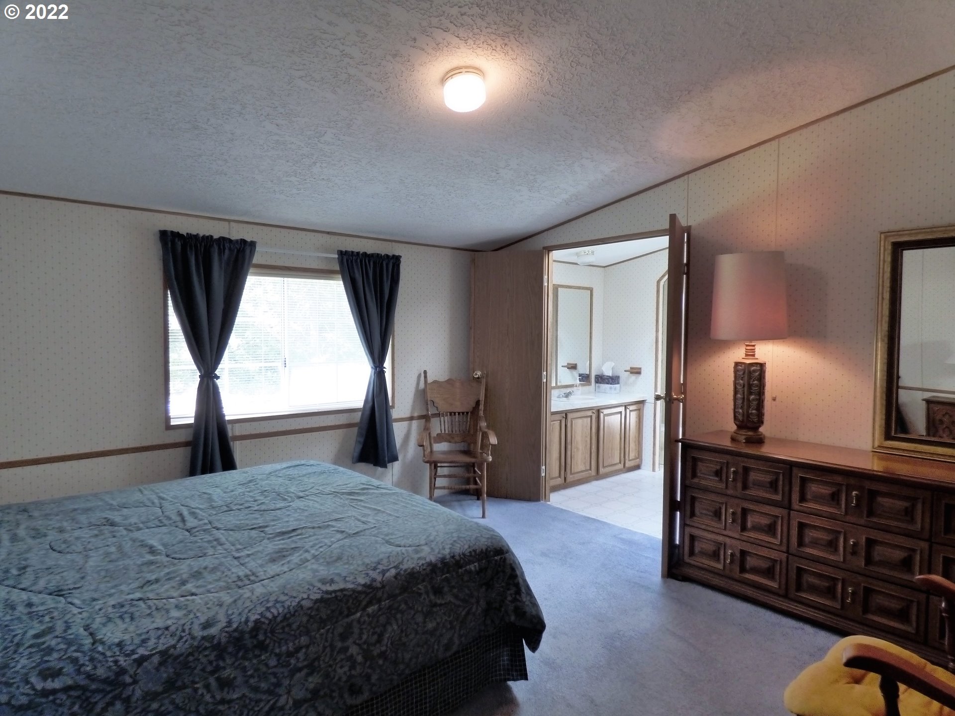 59254 Seven Devils Road Bandon, OR 97411 - Photo 25 of 31 a bedroom with a bed and dresser with mirror
