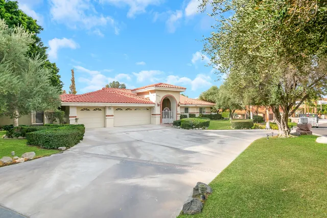 a front view of a house with yard and green space