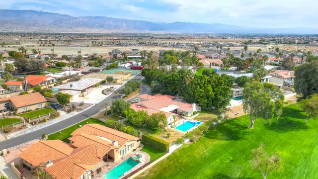 an aerial view of residential houses with outdoor space and trees