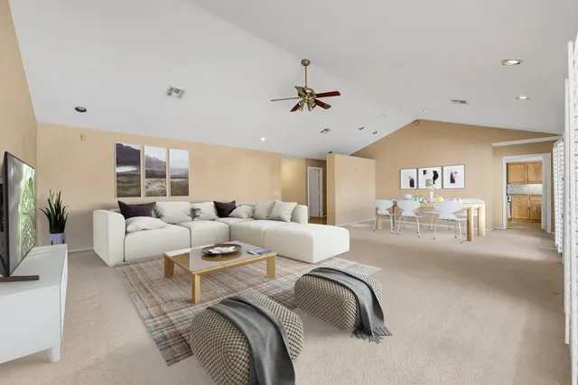 a living room with furniture a chandelier and a flat screen tv