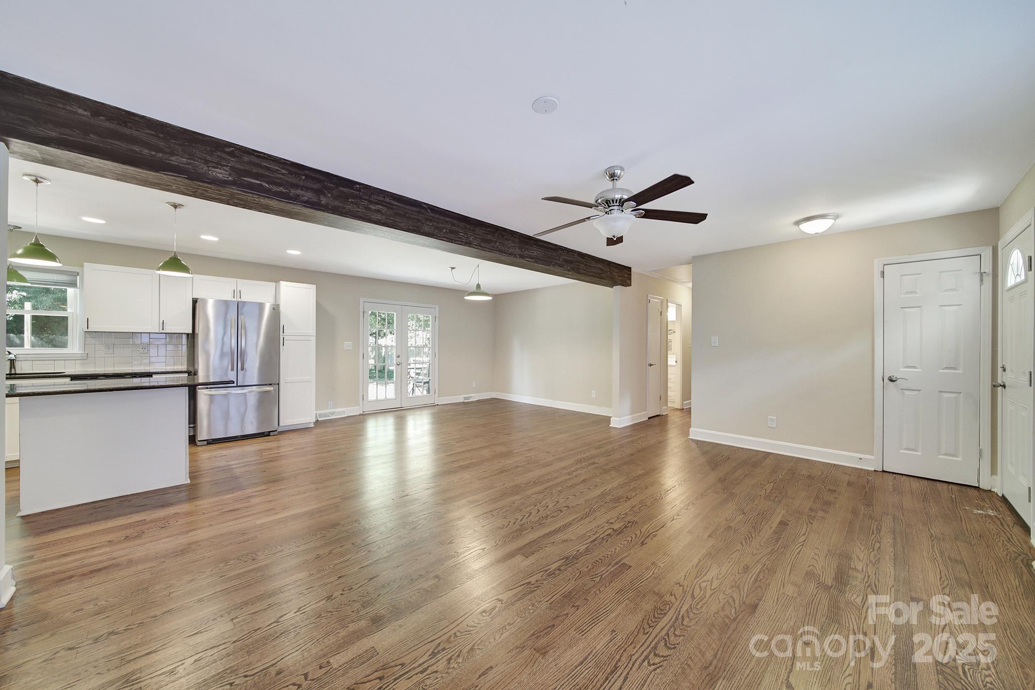 7424 Watercrest Road Charlotte, NC 28210 - Photo 4 of 32 a view of an empty room with wooden floor and a ceiling fan