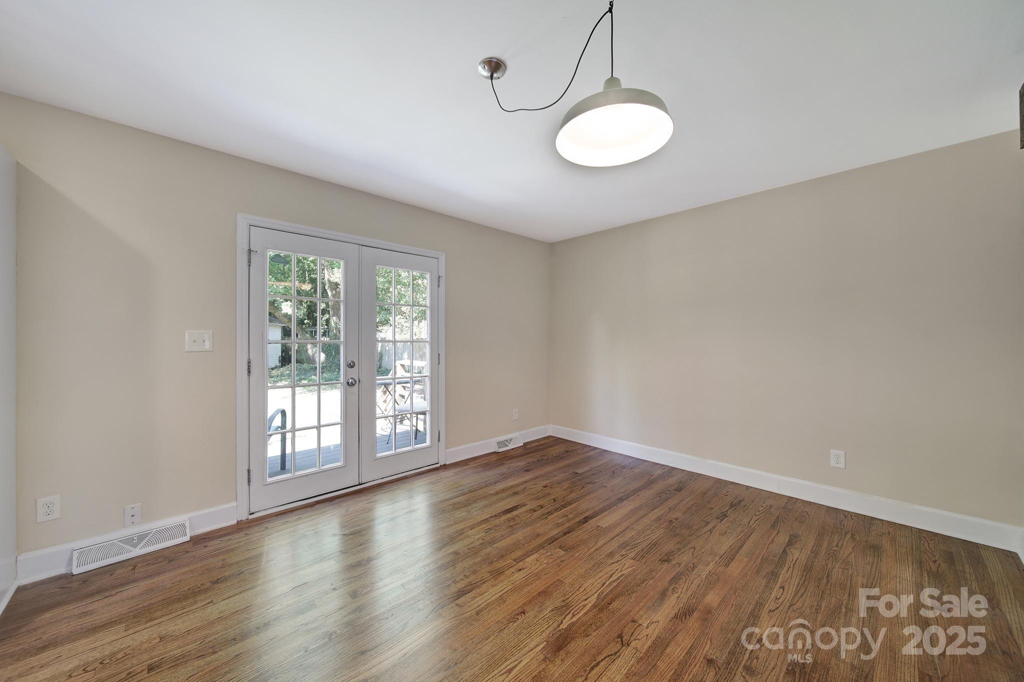 7424 Watercrest Road Charlotte, NC 28210 - Photo 6 of 32 an empty room with wooden floor and windows