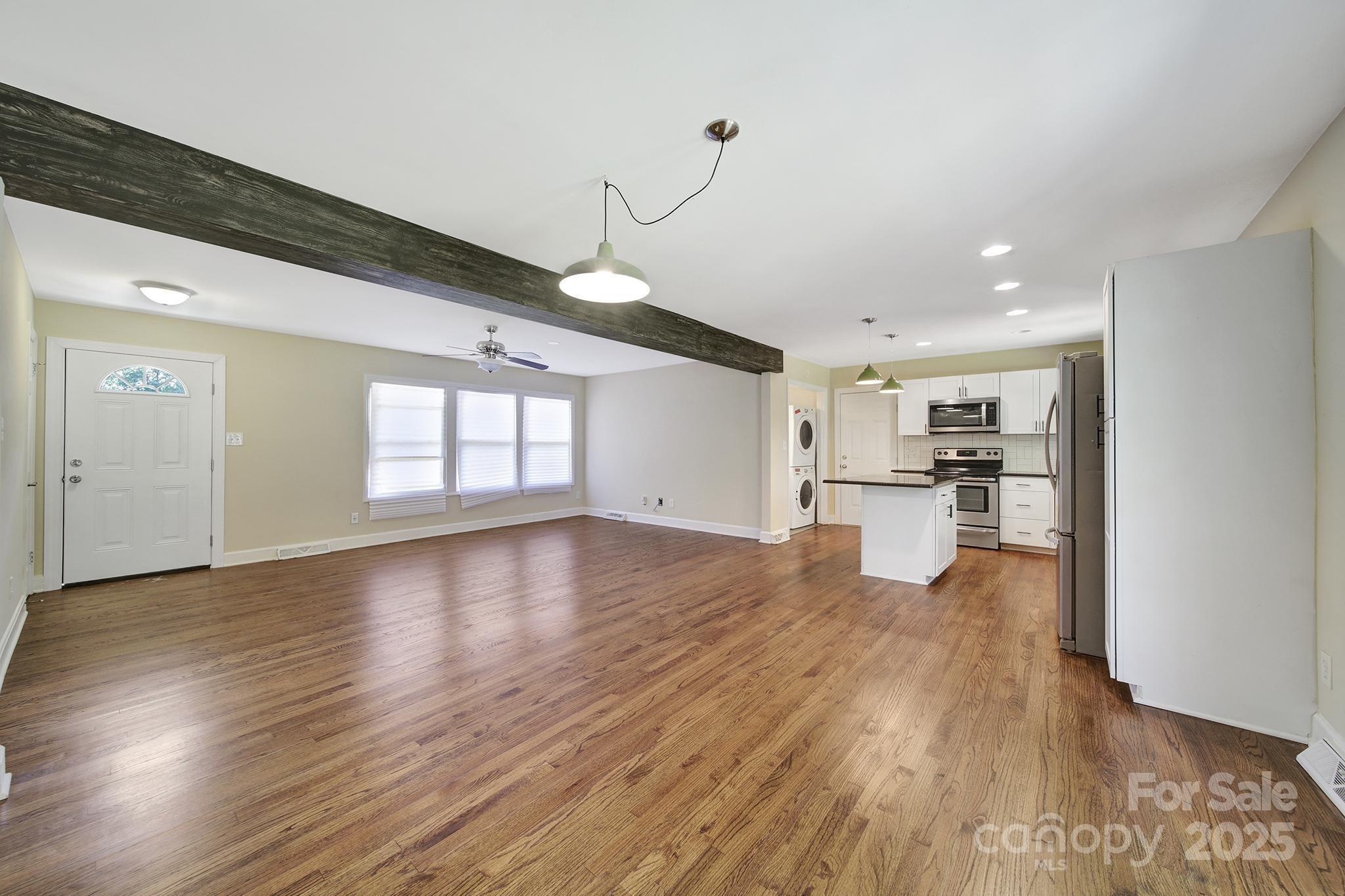 7424 Watercrest Road Charlotte, NC 28210 - Photo 8 of 32 a view of empty room with wooden floor and kitchen view