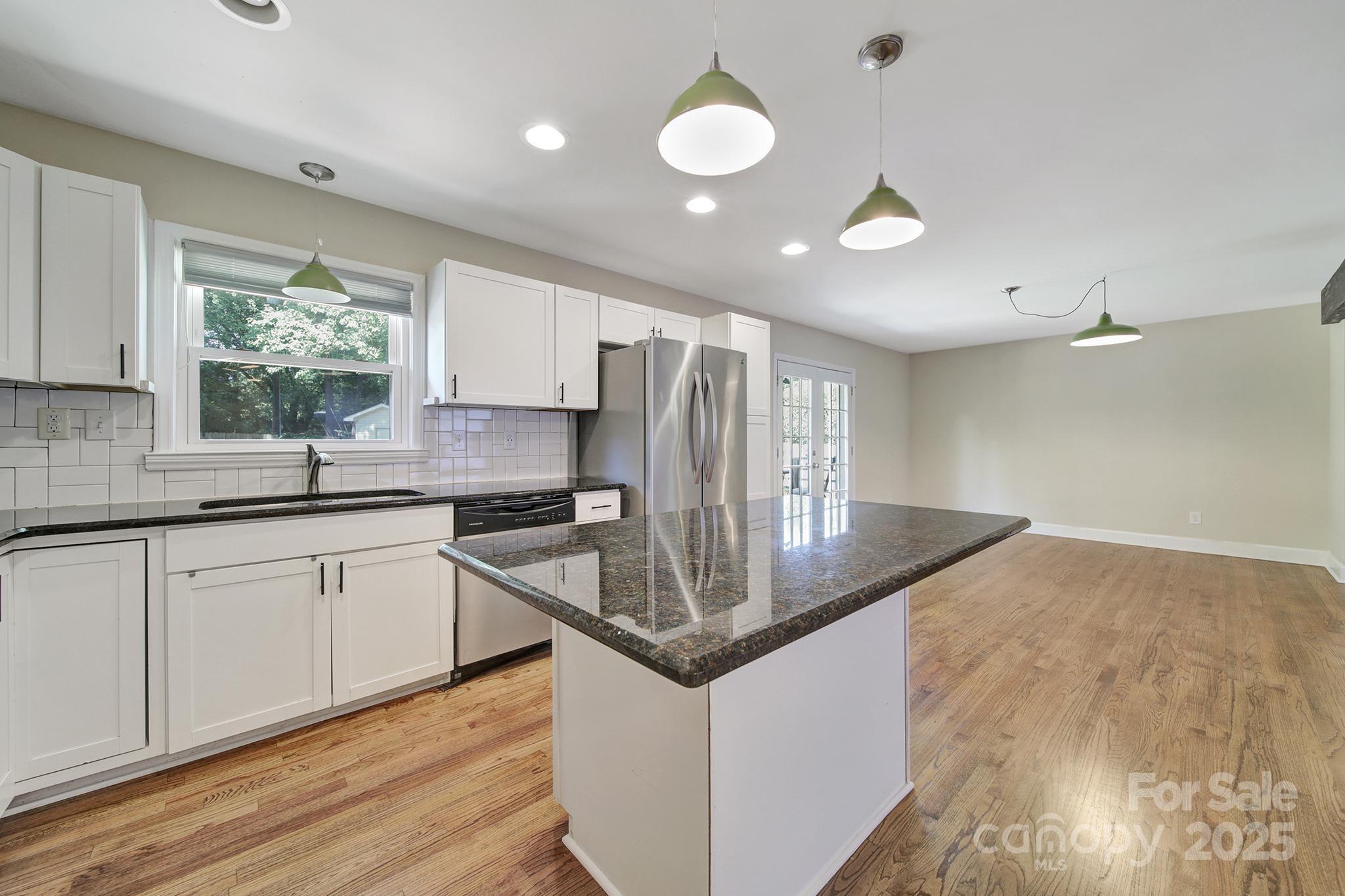 7424 Watercrest Road Charlotte, NC 28210 - Photo 10 of 32 a kitchen with stainless steel appliances granite countertop a sink a stove and a wooden floors