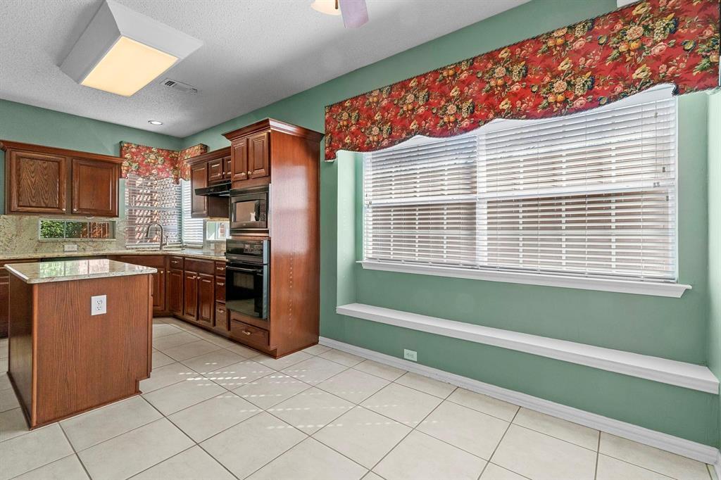 14588 Poe Court Addison, TX 75001 - Photo 13 of 28 a kitchen with stainless steel appliances kitchen island granite countertop a refrigerator and a sink