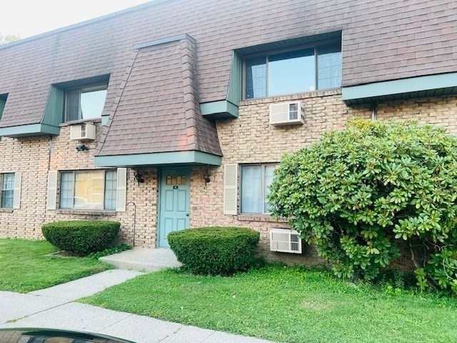 a view of a house with brick walls and a yard with potted plants