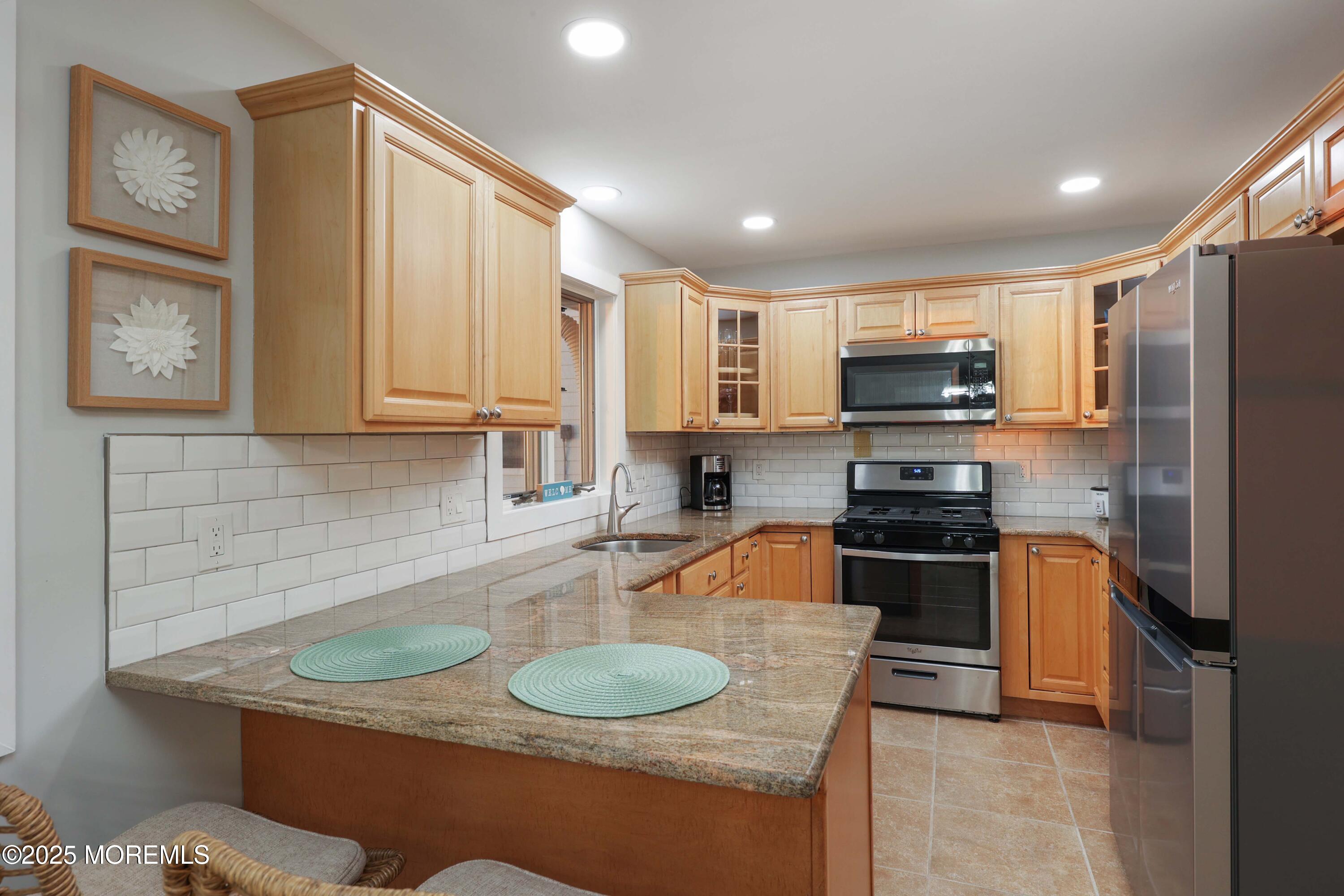 151 Shore Drive Brick, NJ 08723 - Photo 12 of 40 a kitchen with stainless steel appliances granite countertop a sink a stove and a refrigerator