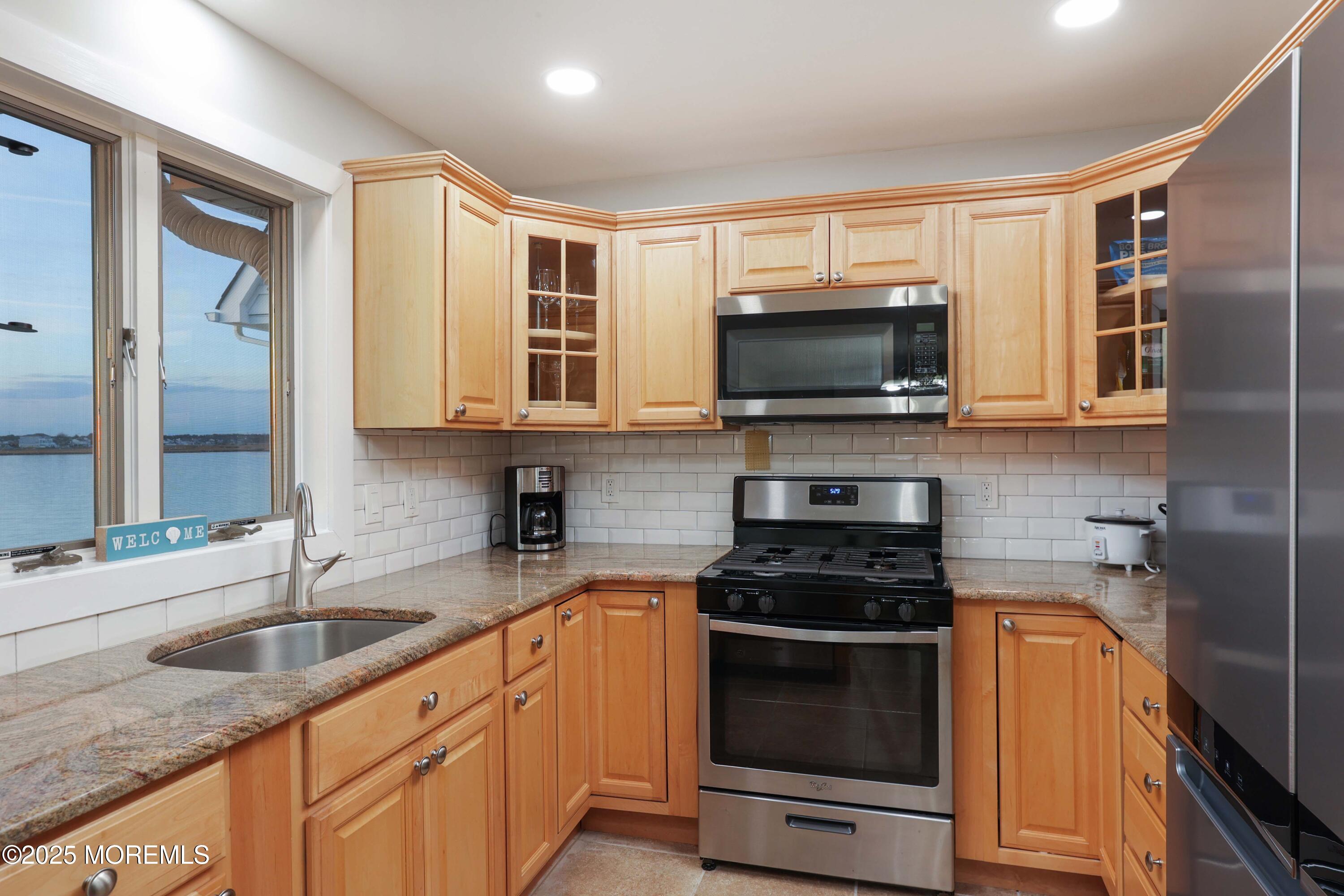 151 Shore Drive Brick, NJ 08723 - Photo 13 of 40 a kitchen with stainless steel appliances a stove sink microwave and cabinets