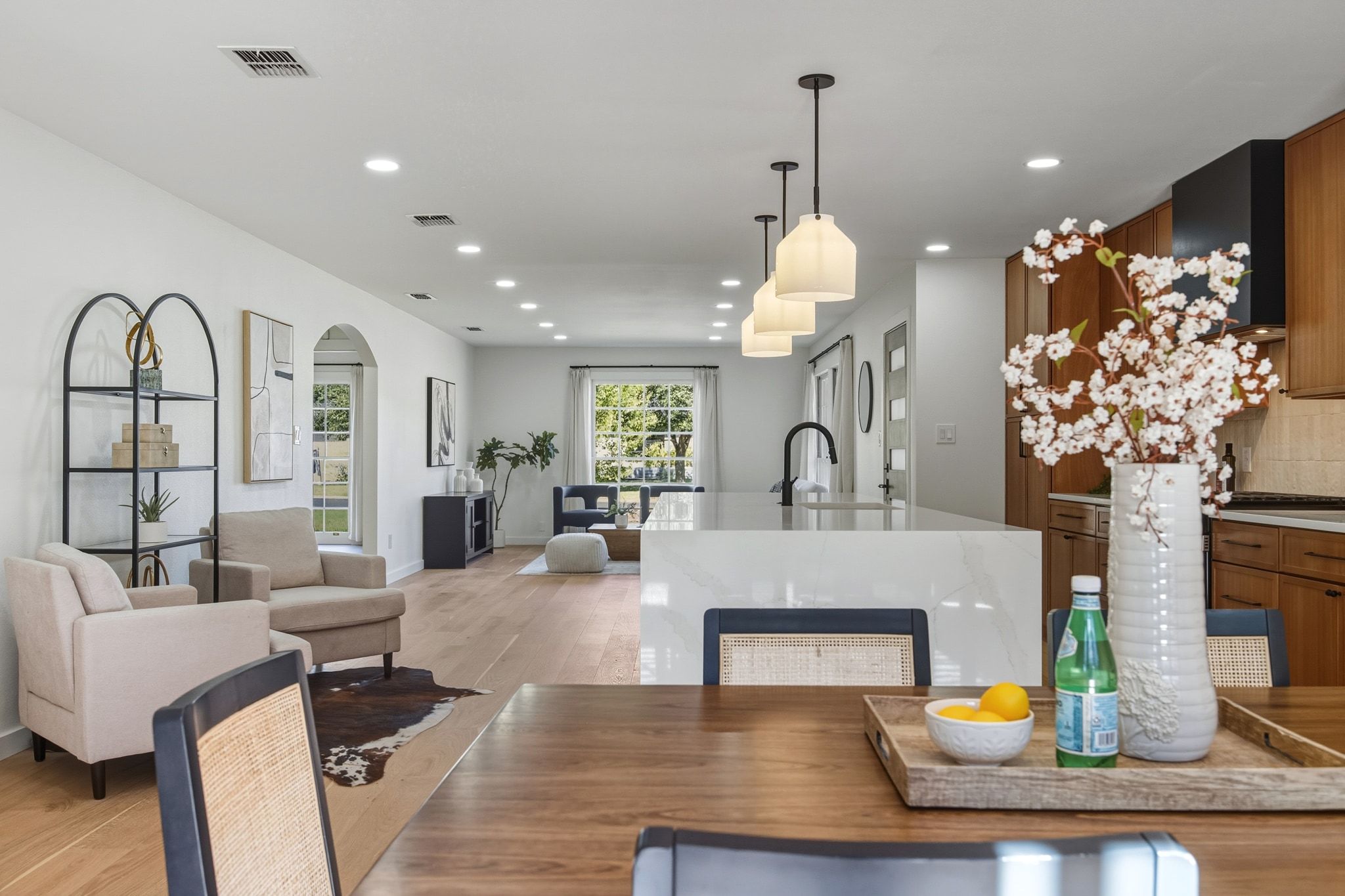 a living room with furniture flowers and a chandelier