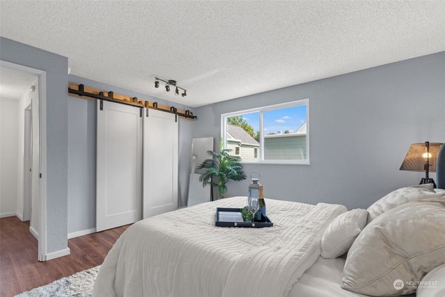 a bedroom with a bed and wooden floor