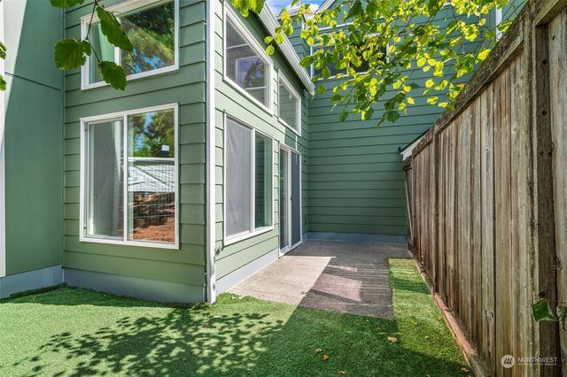 a backyard of a house with plants and outdoor seating