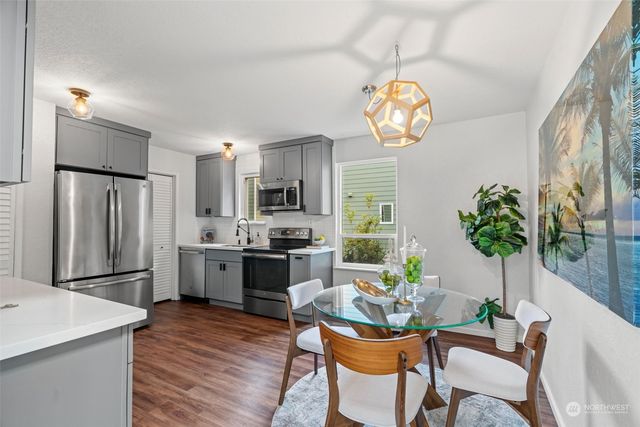 a dining room filled chandelier and wooden floor