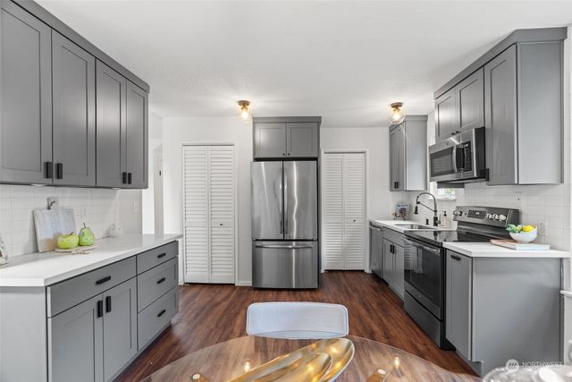 a kitchen with stainless steel appliances a refrigerator sink and microwave