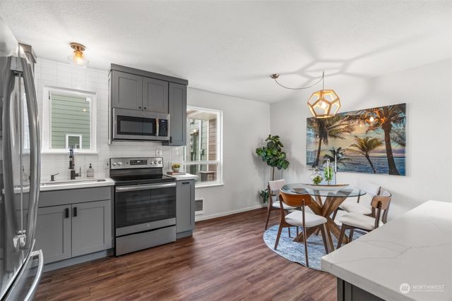 a kitchen with stainless steel appliances a stove a sink refrigerator and a microwave