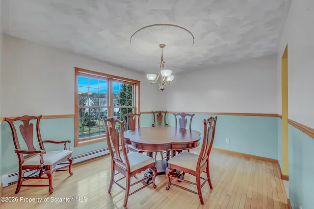 a dining room with furniture a chandelier and wooden floor