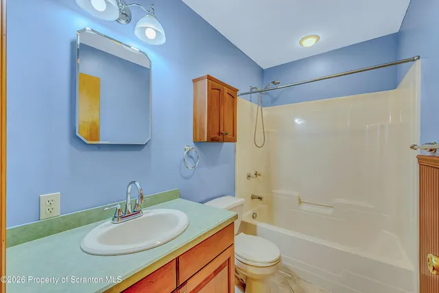 a bathroom with a granite countertop sink a toilet and bathtub