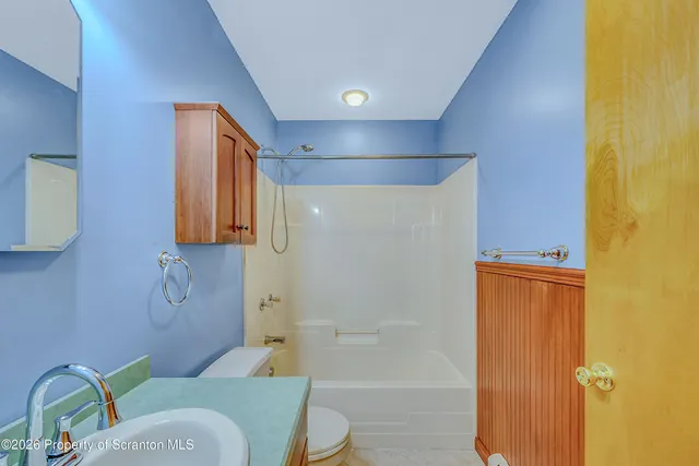 a bathroom with a granite countertop sink a mirror and a bathtub