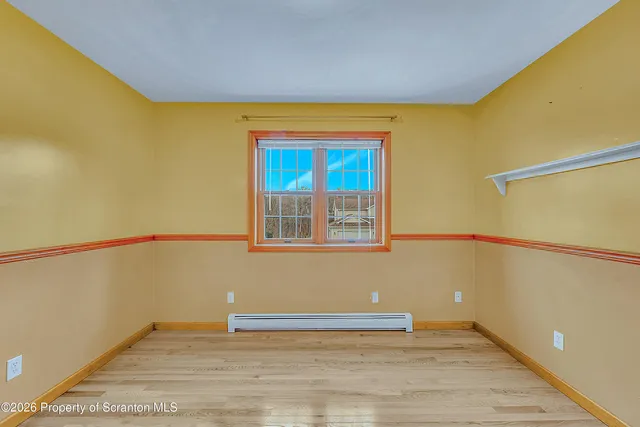a view of a room with wooden floor and a window