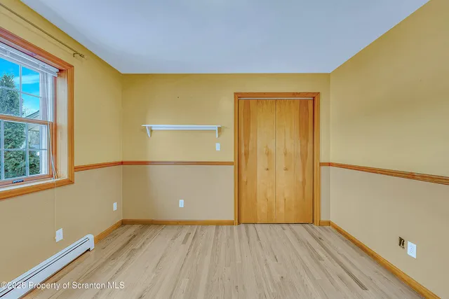 a view of a room with wooden floor and a window