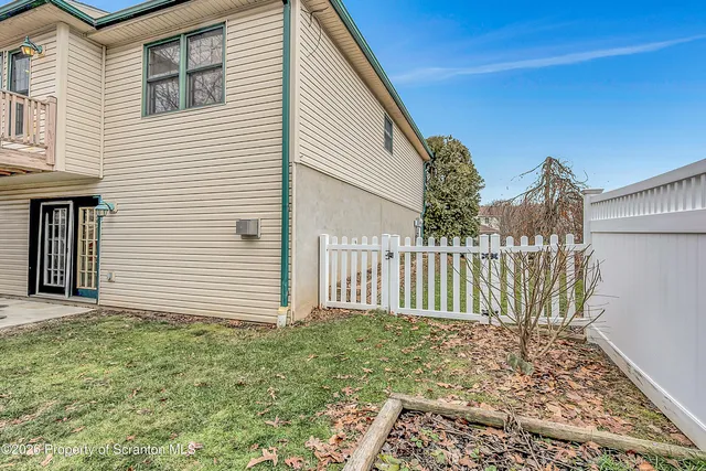 a view of a house with a small yard and wooden floor and fence