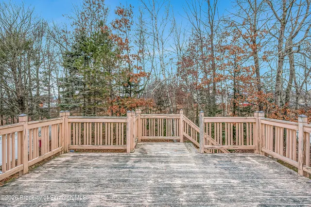 a view of a white house with a small yard and wooden fence