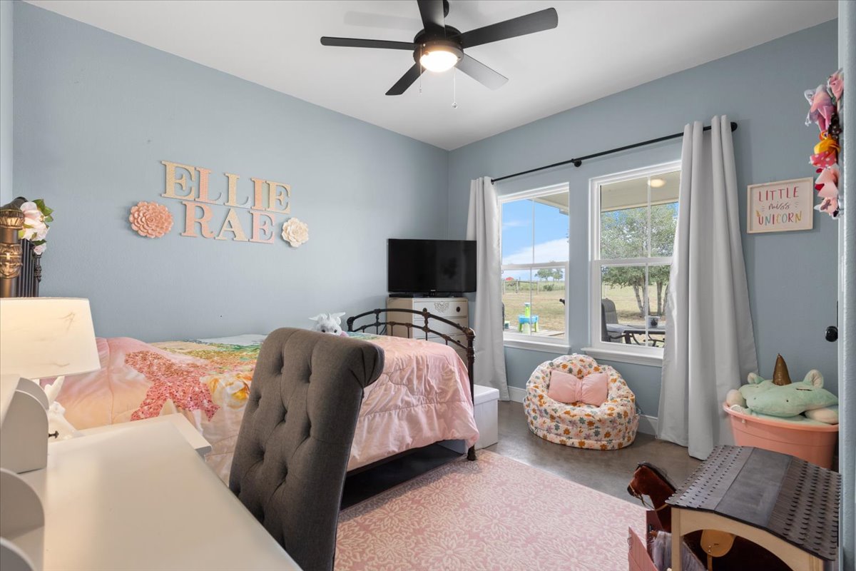 3389 Sparta Field Road Waelder, TX 78959 - Photo 20 of 40 Bedroom featuring concrete flooring and a ceiling fan