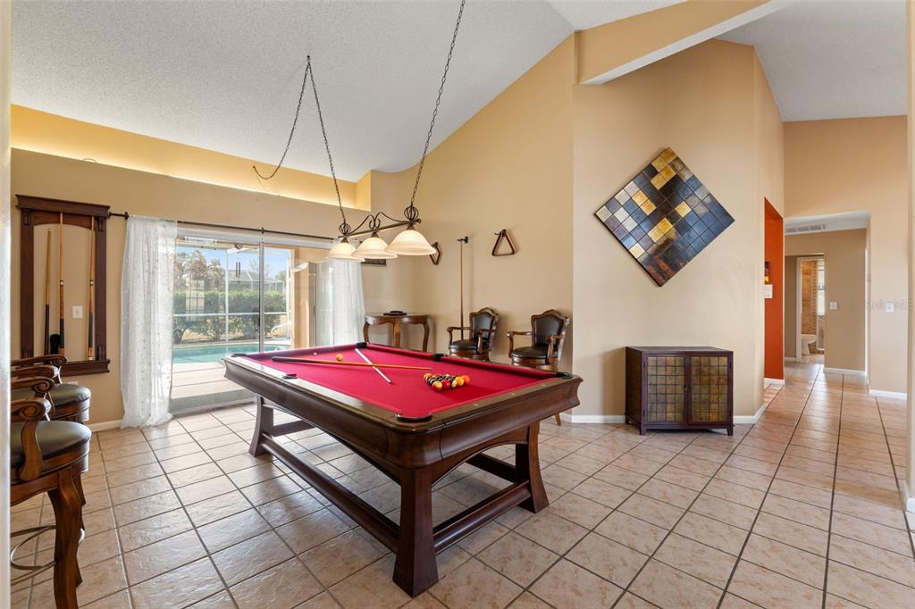 14122 Newcastle Avenue Spring Hill, FL 34609 - Photo 12 of 66 a living room with furniture a flat screen tv and a table