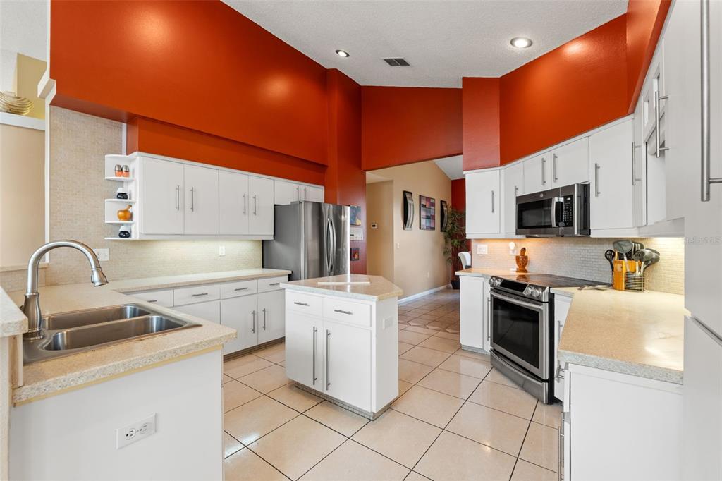 14122 Newcastle Avenue Spring Hill, FL 34609 - Photo 21 of 66 a kitchen with stainless steel appliances a stove microwave and sink