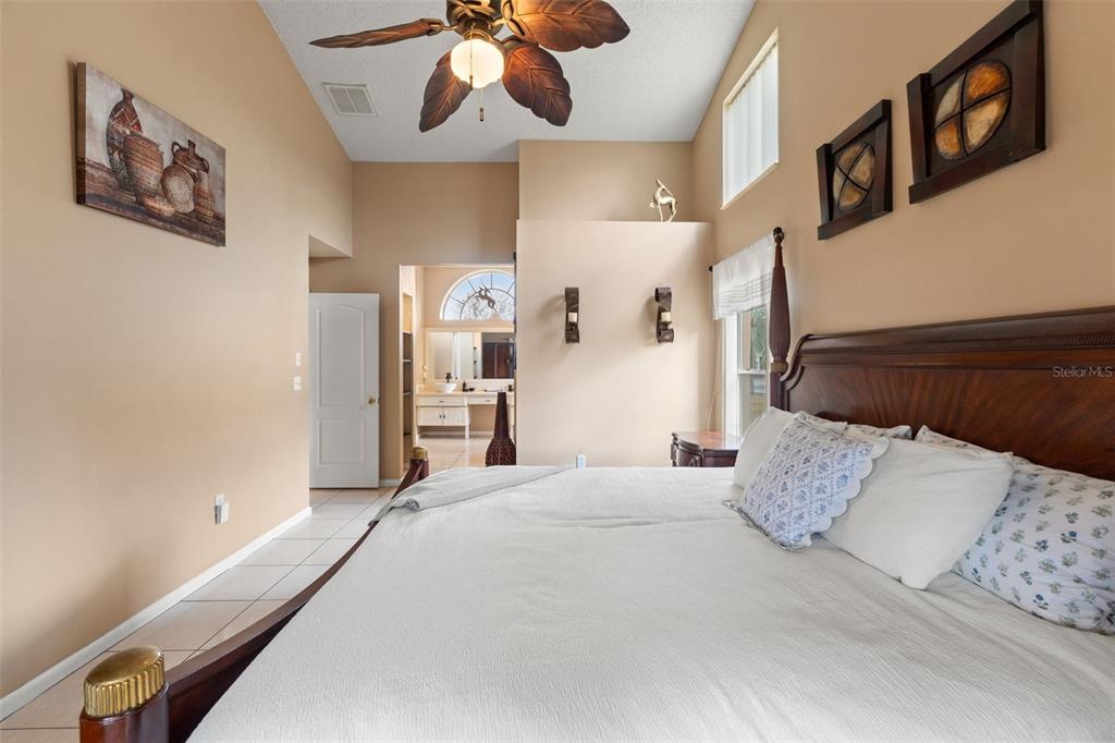 14122 Newcastle Avenue Spring Hill, FL 34609 - Photo 42 of 66 a bedroom with a large bed and a chandelier