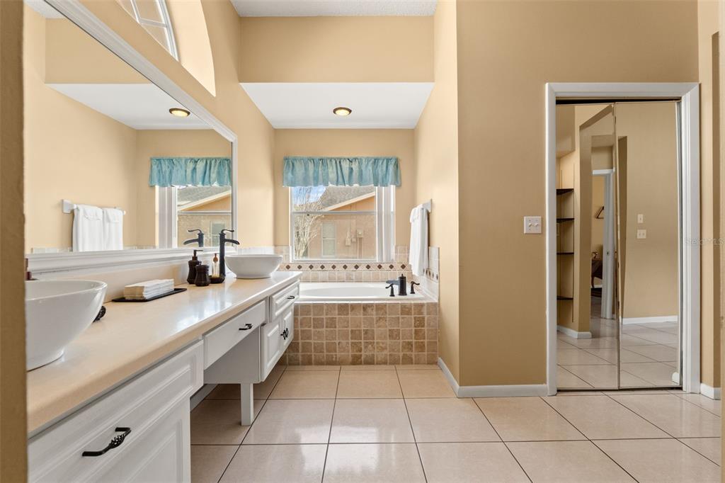 14122 Newcastle Avenue Spring Hill, FL 34609 - Photo 48 of 66 a large bathroom with a granite countertop double vanity sink a mirror and a bathtub