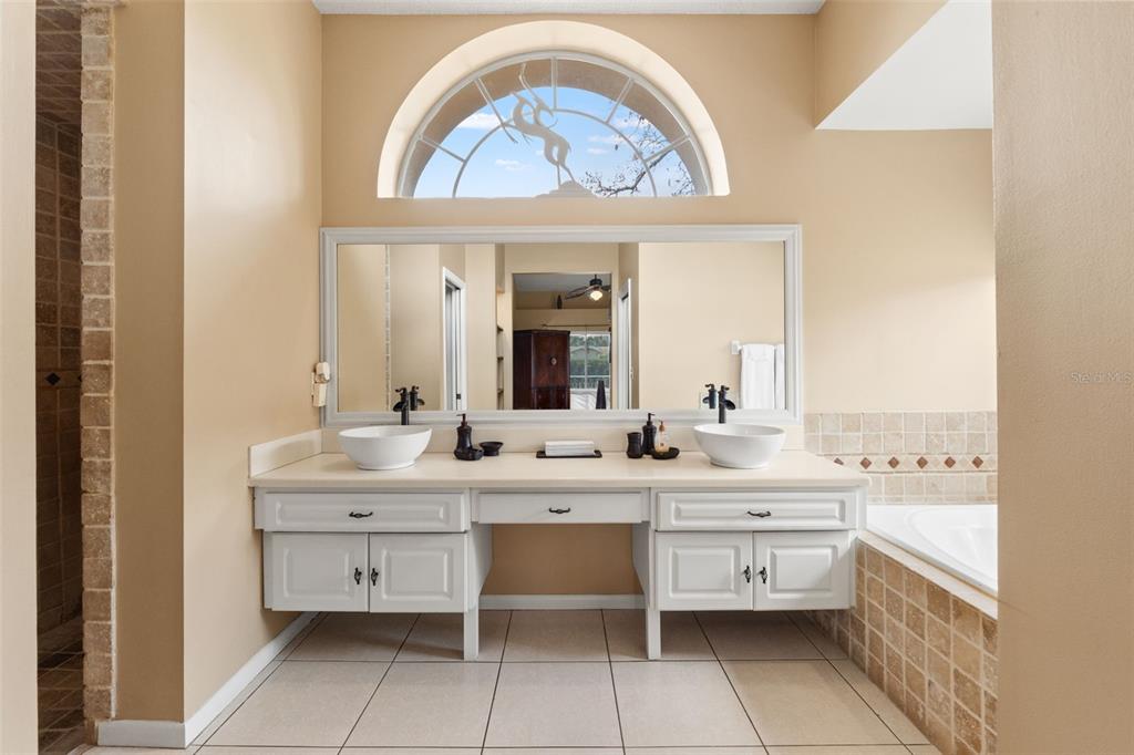 14122 Newcastle Avenue Spring Hill, FL 34609 - Photo 51 of 66 a large bathroom with a double vanity sink a mirror and a bathtub