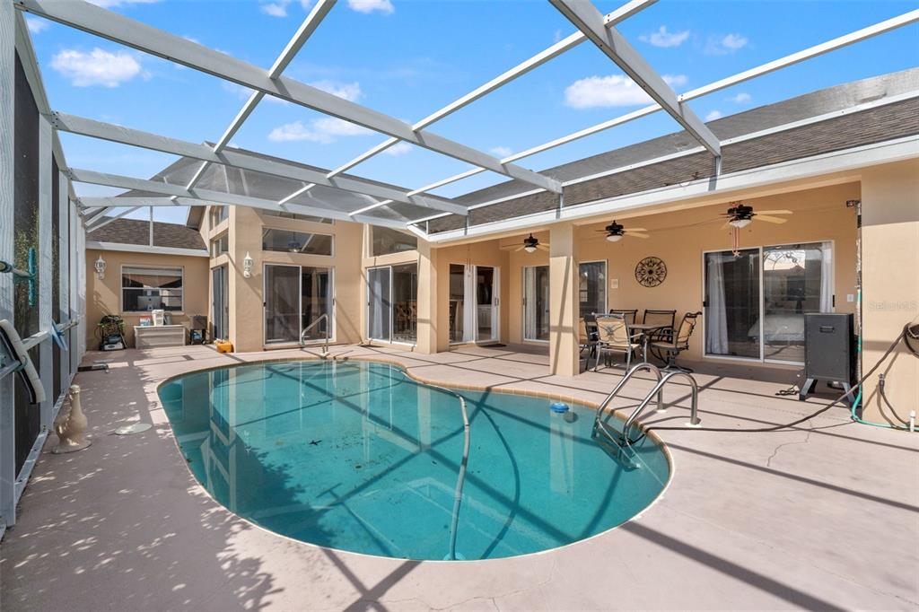 14122 Newcastle Avenue Spring Hill, FL 34609 - Photo 56 of 66 a view of a swimming pool with outdoor seating
